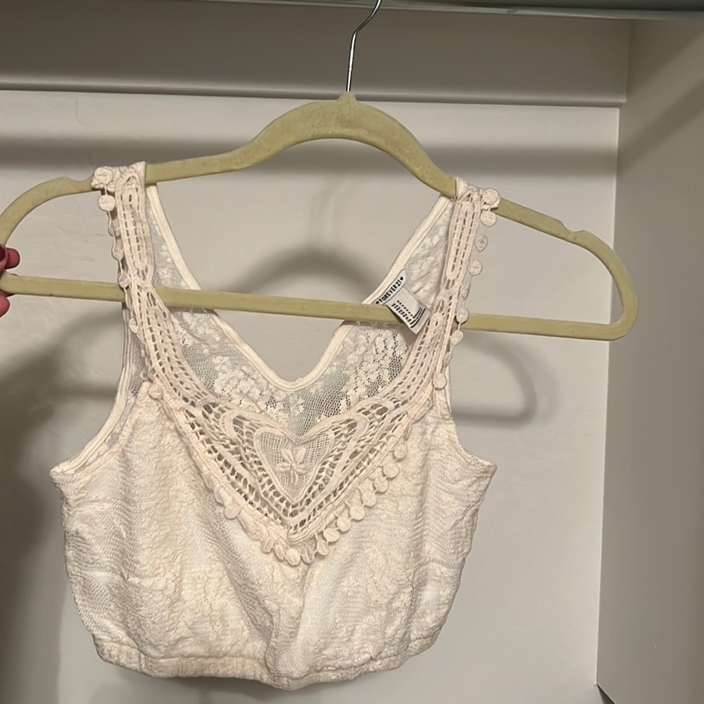 Forever 21 cropped off white lace shirt and is see through in the back.
